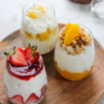 cottage cheese and fruit in small glasses on a wooden plate