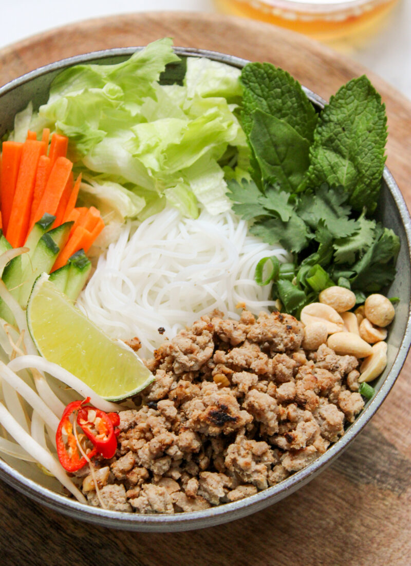 Bowl with vermicelli noodles and toppings arranged around the sides of the bowl