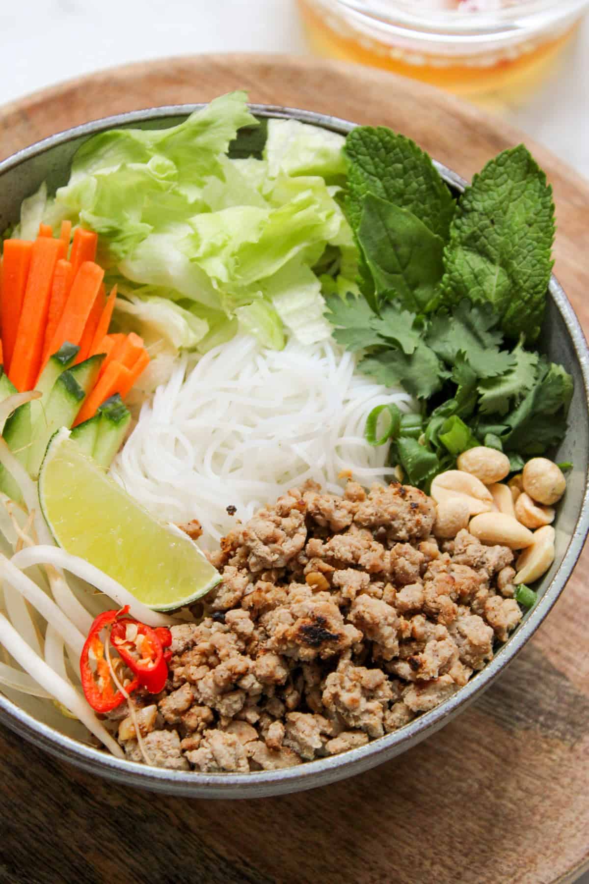 Bowl with vermicelli noodles and toppings arranged around the sides of the bowl