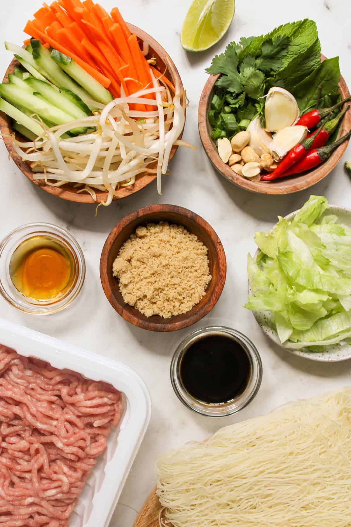 Ingredients for Vietnamese vermicelli bowls arranged in small bowls on a marble counter top