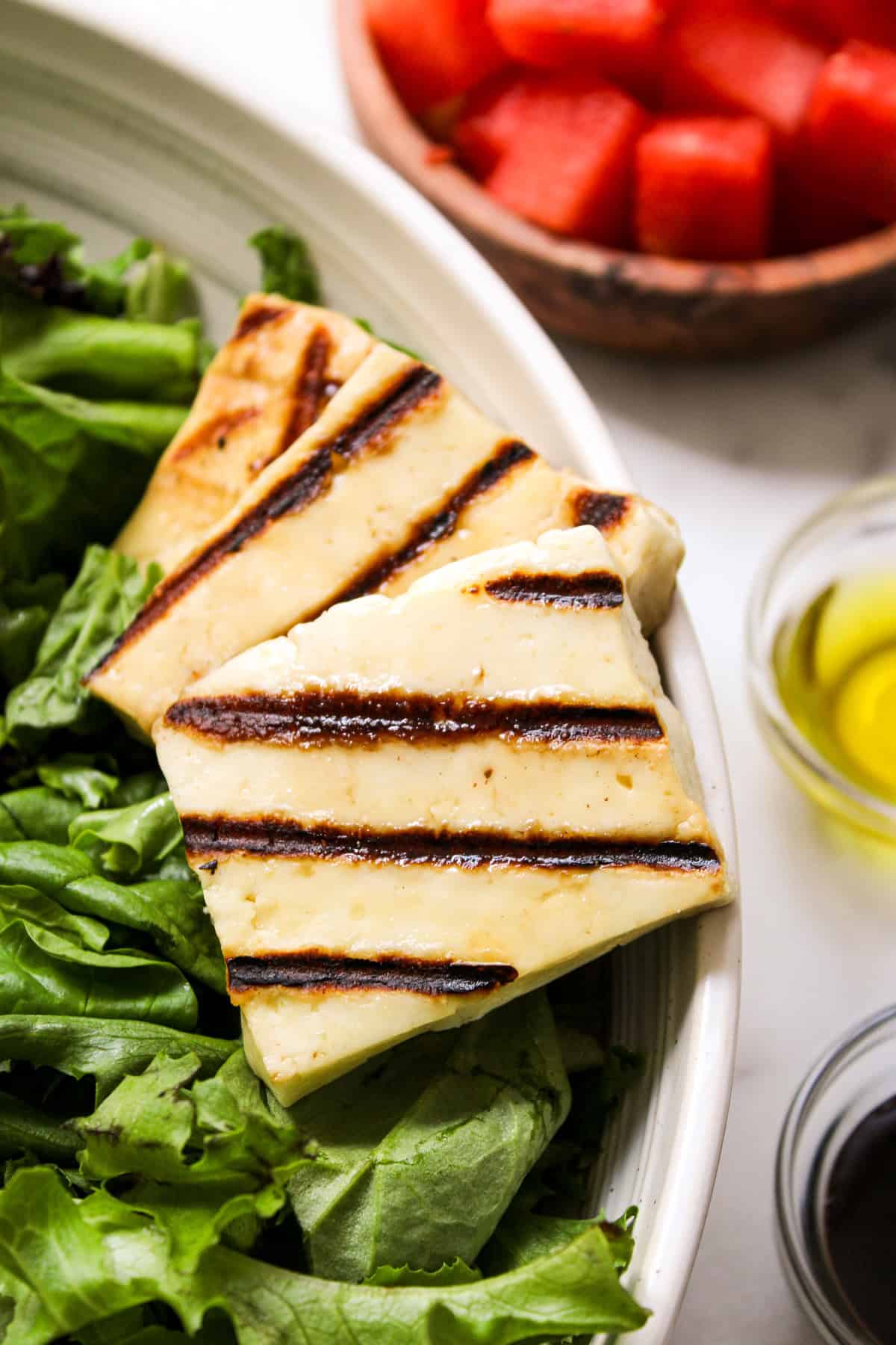 close-up of grilled halloumi cheese on a bed of lettuce