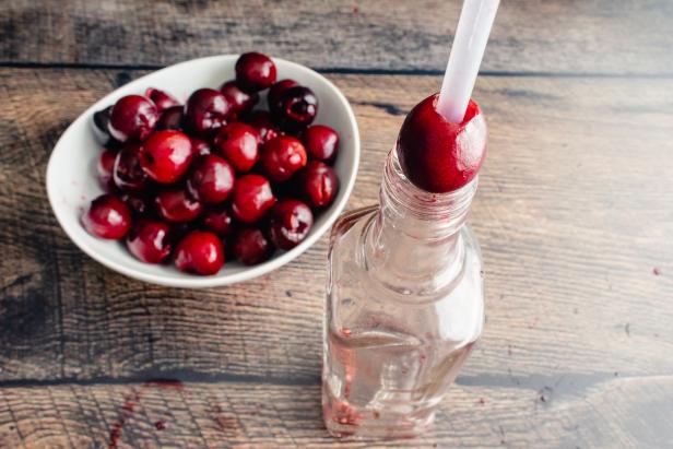 pitting a cherry using a straw and bottle