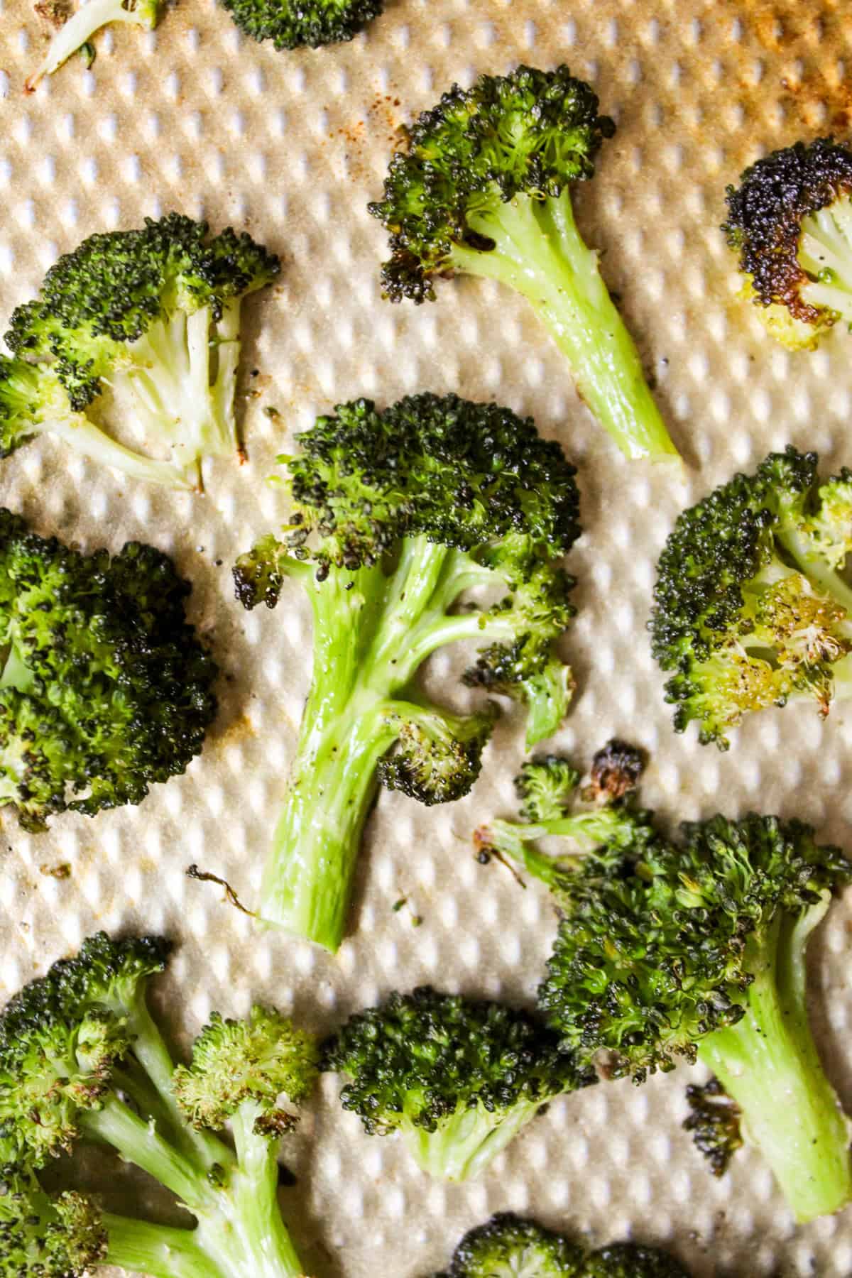 close up shot of roasted broccoli on a metal sheet pan