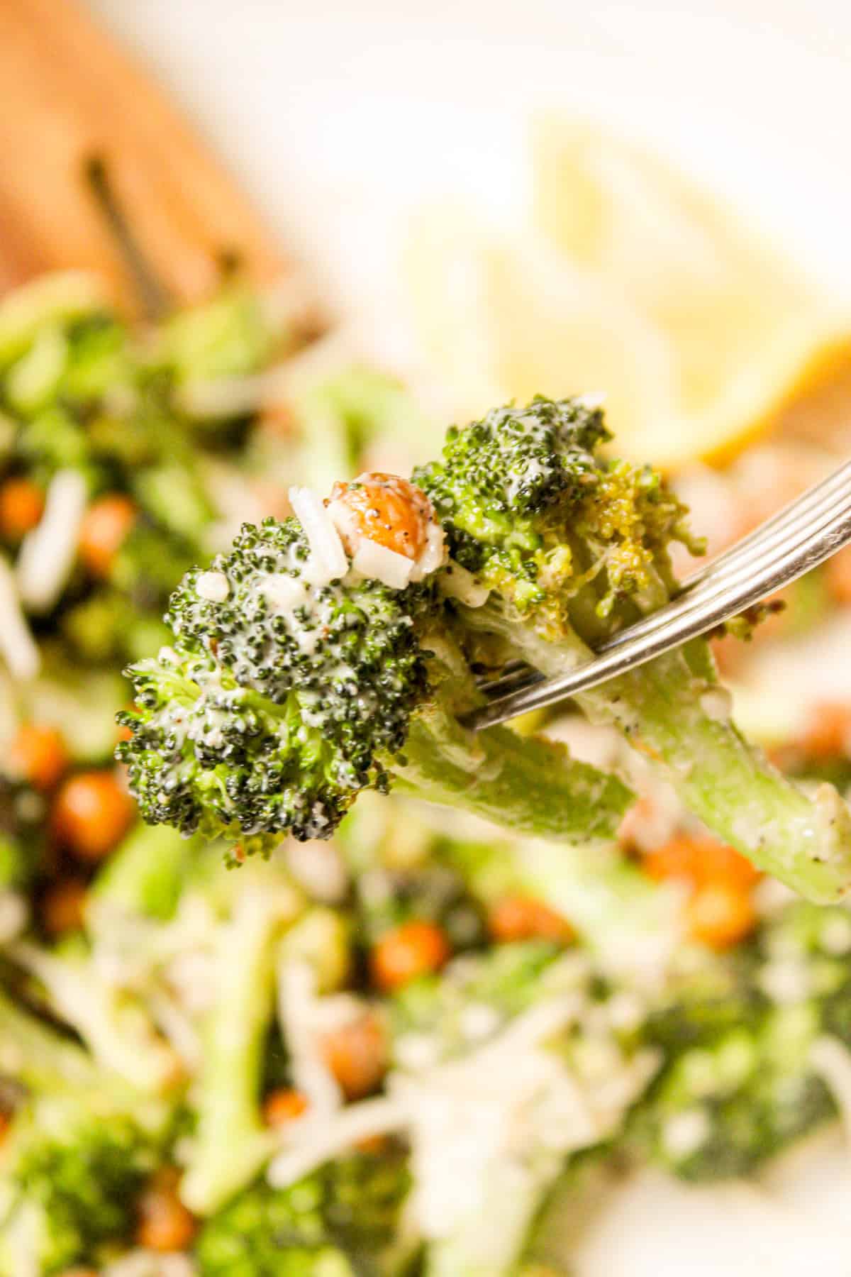 close up shot of a floret of roasted broccoli with tahini caesar dressing on a metal fork